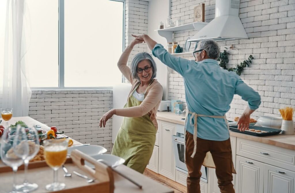 Elderly couple dancing in the kitchen.